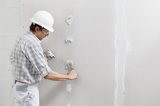 House Painter Applying Mud Before Repairing Drywall of a Tampa Property