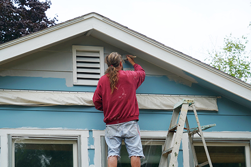 Man Trying To Paint Own House Instead of Hiring Painter with Residential Exterior Painting Service in Tampa FL