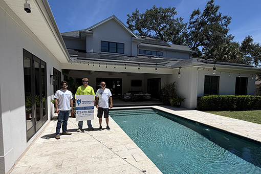 Three House Painters Posing In Front of House After Residential Exterior Painting Services
